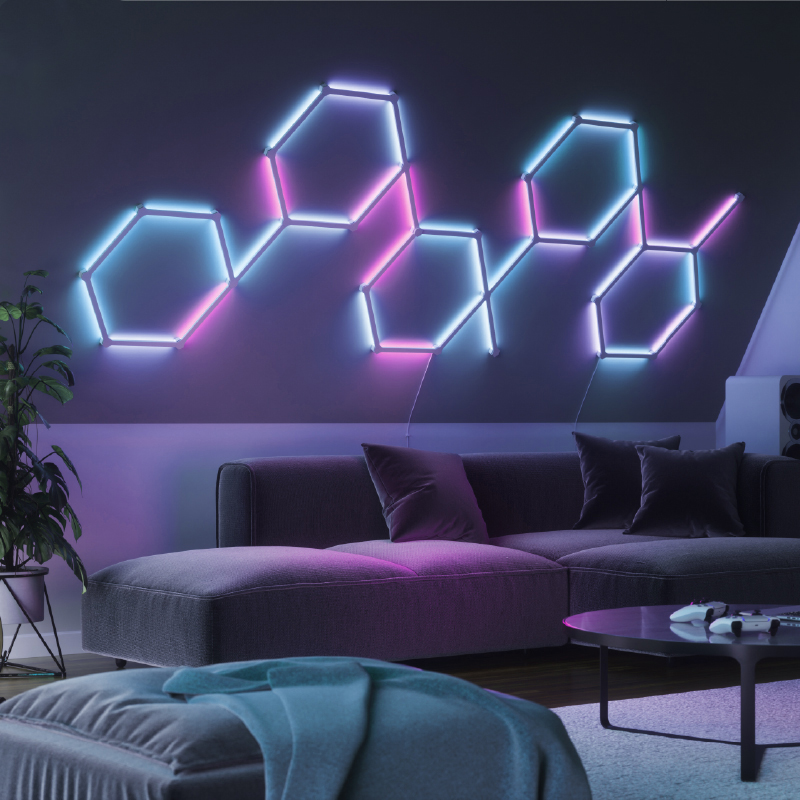 Líneas de luz inteligentes, retroiluminadas, modulares y que cambian de color habilitadas para Thread de Nanoleaf Lines montadas en la pared de una sala de estar. HomeKit, Google Assistant, Amazon Alexa, IFTTT.